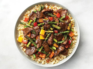 a top down view of a bowl of beef and asparagus stir-fry