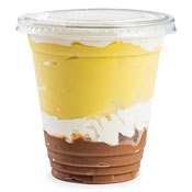 A cup of mostly vanilla pudding with a layer of whipped topping diving the vanilla and chocolate