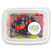 raspberries, blueberries, blackberries and sliced kiwi in a plastic container