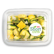 sliced zucchini, summer squash, white onions, and asparagus in a plastic container