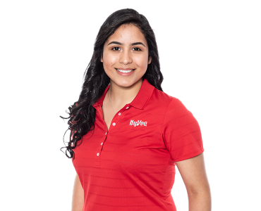 A woman wearing a red Hy-Vee polo and smiling